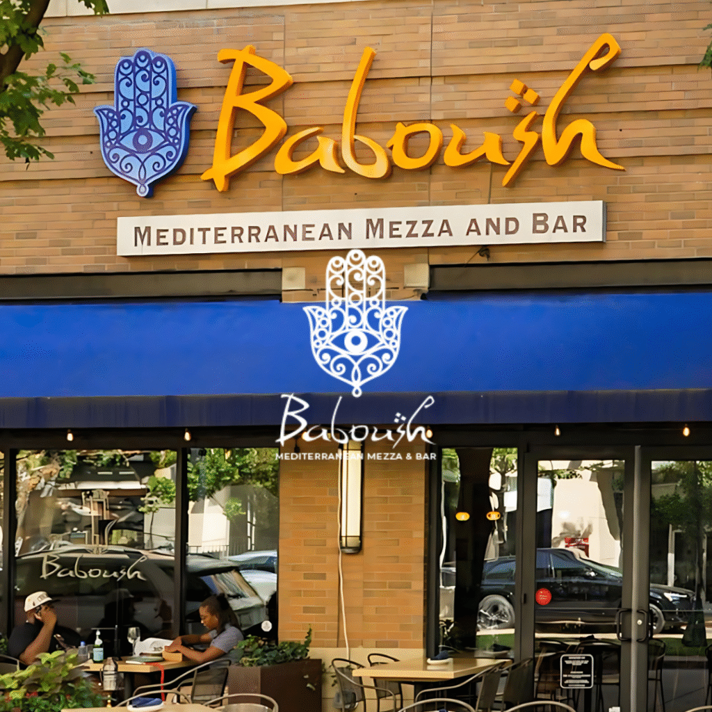 Exterior view of Baboush restaurant with blue awning, signage, and outdoor dining tables.