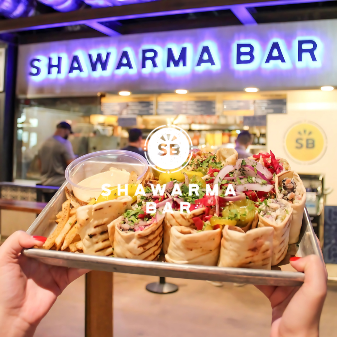 Tray of shawarma wraps and fries in front of Shawarma Bar at Legacy Food Hall in Plano, Texas.
