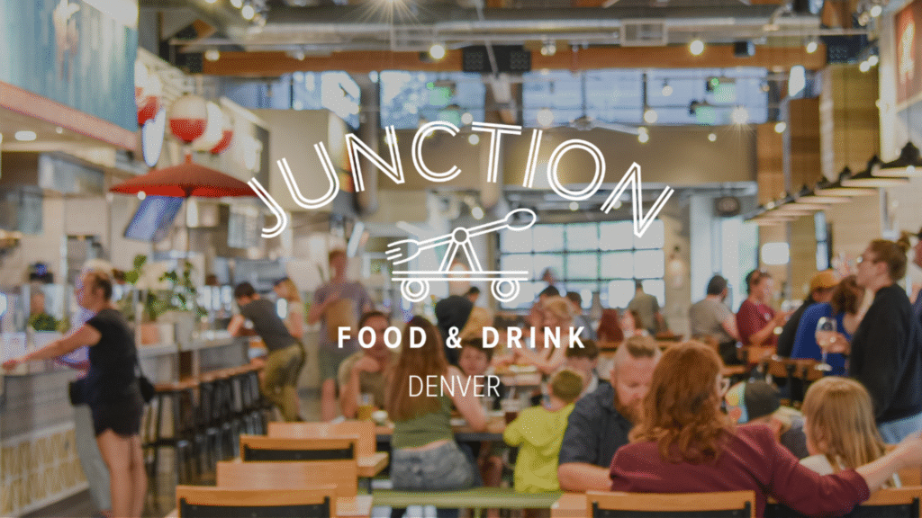 Interior of Junction Food & Drink food hall in Denver, Colorado, featuring multiple artisanal food stalls and a central 40-foot bar.